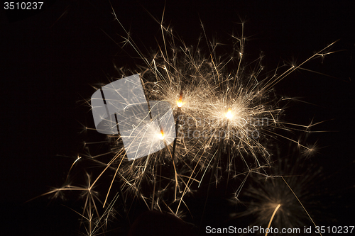 Image of Burning sparklers on black background