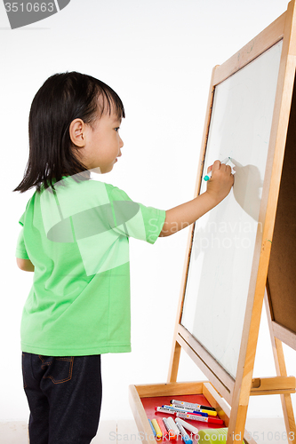 Image of Chinese little girl writing on whiteboard