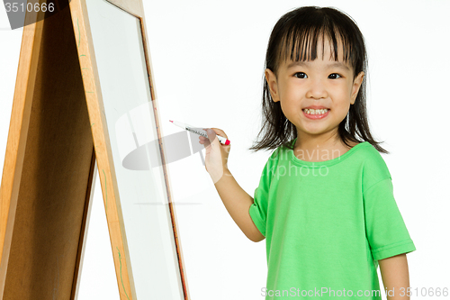 Image of Chinese little girl writing on whiteboard