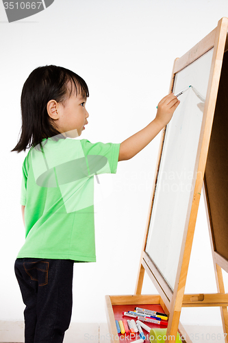 Image of Chinese little girl writing on whiteboard