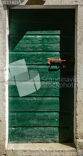 Image of old green ragged shabby wooden door