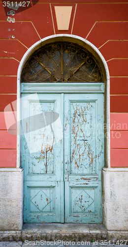 Image of old blue ragged shabby wooden door