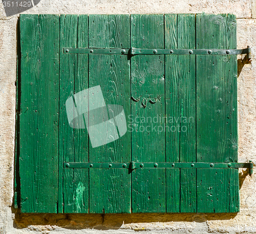 Image of old window with  closed shutters