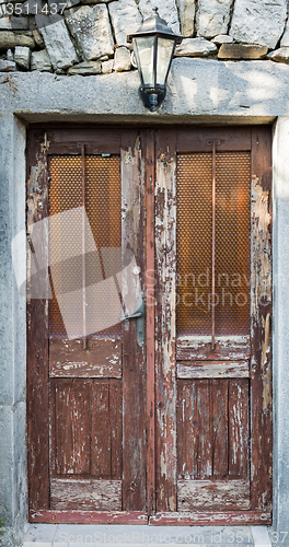 Image of old brown yellow ragged shabby wooden door