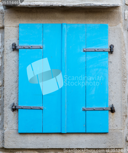 Image of old window with  closed blue wooden shutters