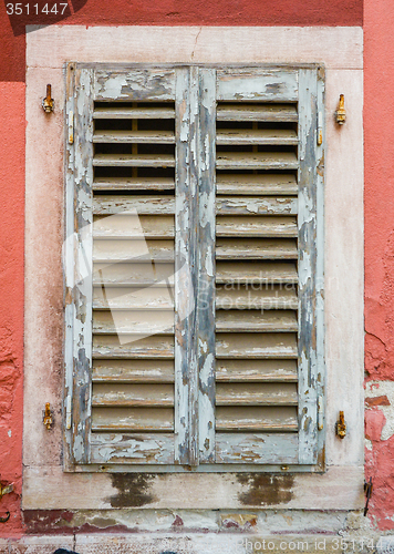 Image of old window with  closed shutters