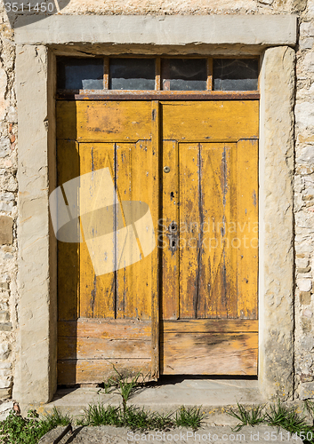 Image of yellow ragged shabby wooden door