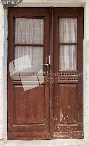 Image of old brown yellow ragged shabby wooden door