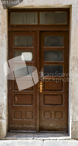 Image of old brown ragged shabby wooden door