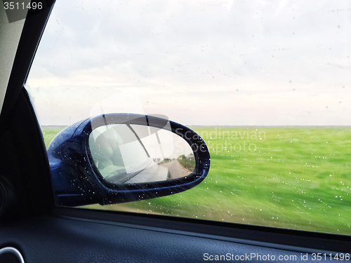 Image of View over green fields from a modern car