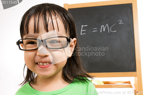 Image of Asian Chinese little girl againts blackboard with formulas