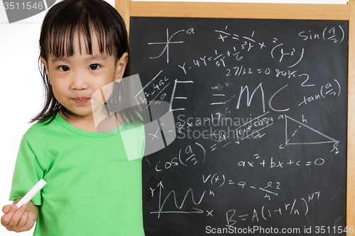 Image of Asian Chinese little girl againts blackboard with formulas