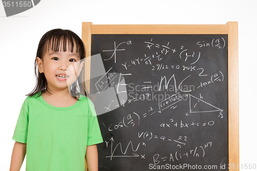 Image of Asian Chinese little girl againts blackboard with formulas