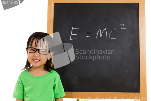 Image of Asian Chinese little girl againts blackboard with formulas