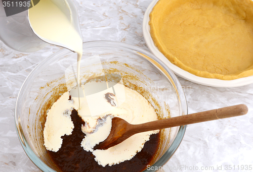 Image of Pouring cream into pumpkin pie filling