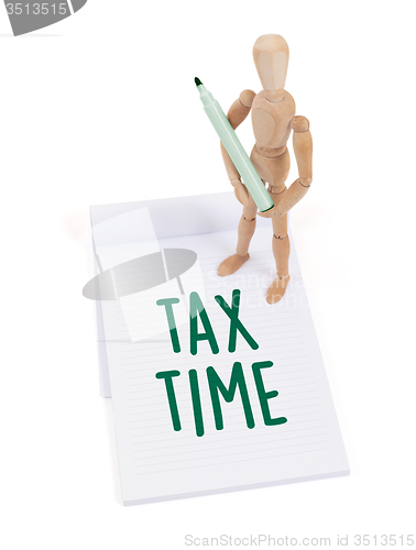 Image of Wooden mannequin writing - Tax time