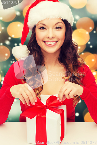 Image of smiling woman in santa helper hat with gift box