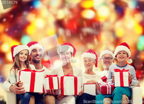 Image of happy family in santa helper hats with gift boxes