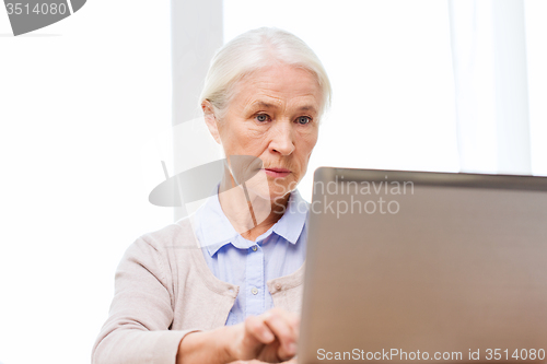 Image of senior woman with laptop at home