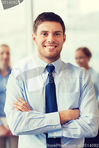 Image of smiling businessman with colleagues in office