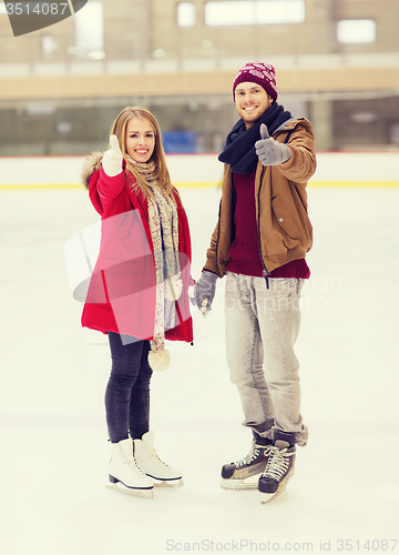 Image of happy couple holding hands on skating rink