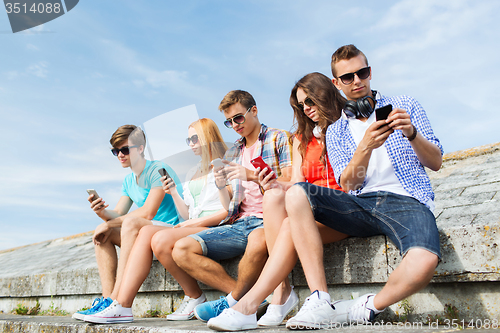 Image of group of friends with smartphone outdoors
