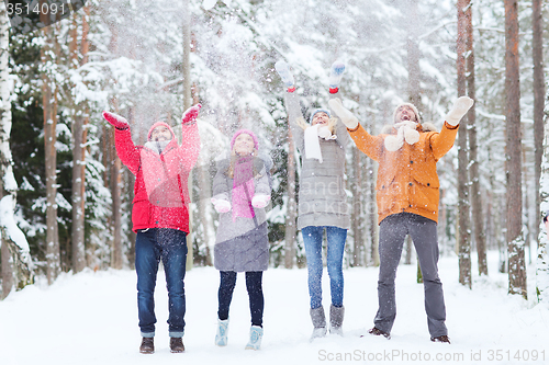 Image of group of happy friends playin with snow in forest