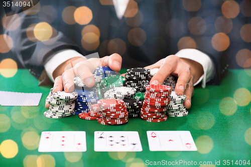 Image of poker player with cards and chips at casino