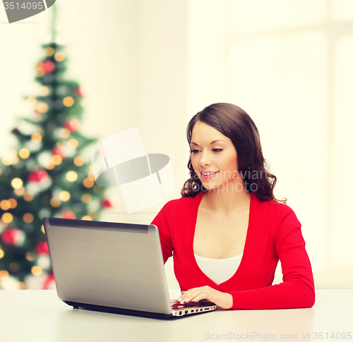 Image of smiling woman in red clothes with laptop computer