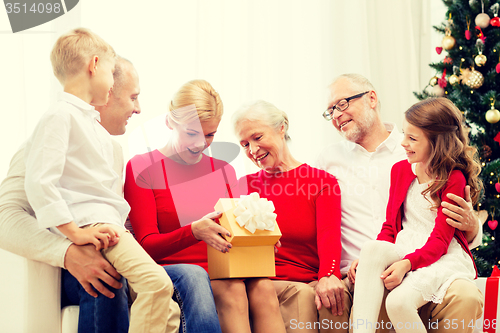 Image of smiling family with gifts at home