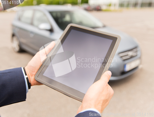 Image of close up of young man with tablet pc and car