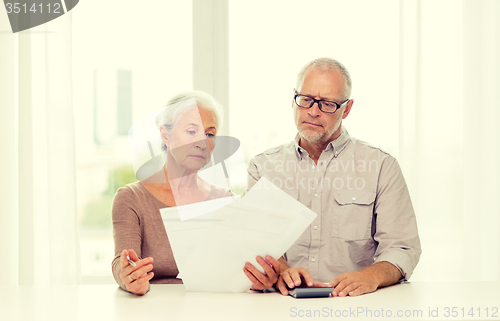 Image of senior couple with papers and calculator at home