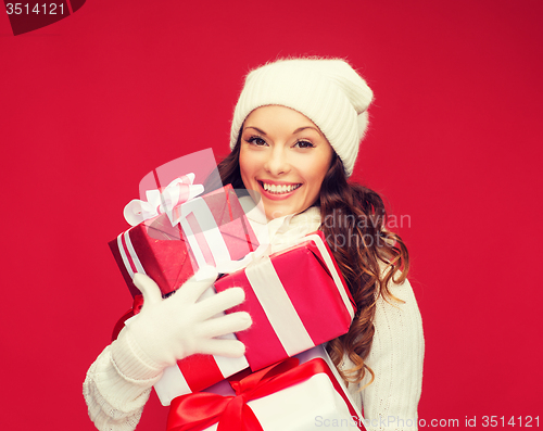 Image of woman in sweater and hat with many gift boxes