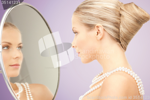 Image of beautiful woman with pearl necklace and mirror