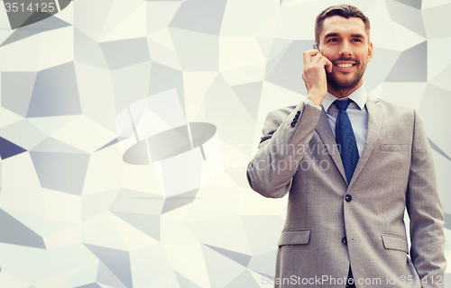 Image of smiling businessman with smartphone outdoors