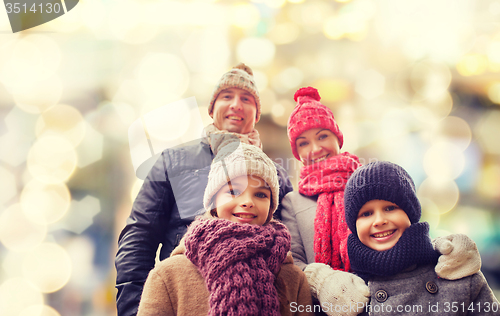 Image of happy family in winter clothes outdoors