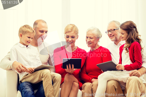 Image of smiling family with tablet pc computers at home