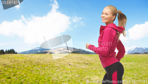 Image of happy sporty woman running or jogging outdoors