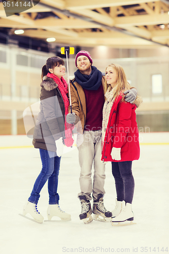 Image of happy friends taking selfie on skating rink