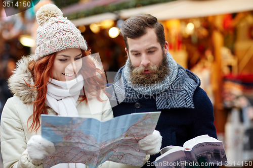 Image of happy couple with map and city guide in old town