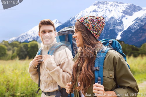 Image of smiling couple with backpacks hiking