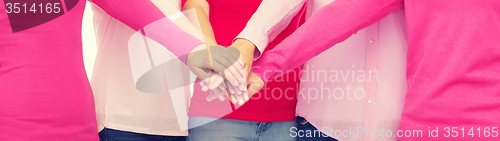 Image of close up of women in pink shirts with hands on top