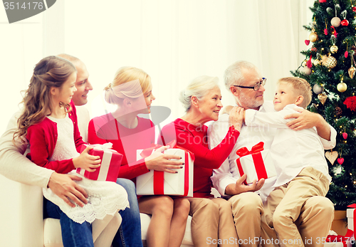 Image of smiling family with gifts at home