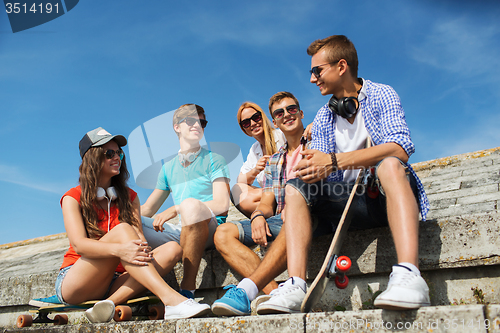 Image of happy teenage friends with longboard on street