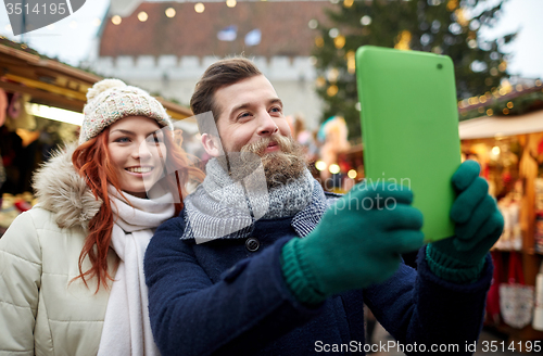 Image of couple taking selfie with tablet pc in old town