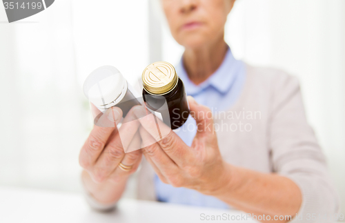 Image of close up of senior woman with medicine jars