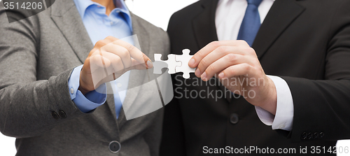 Image of businessman and businesswoman with puzzle pieces