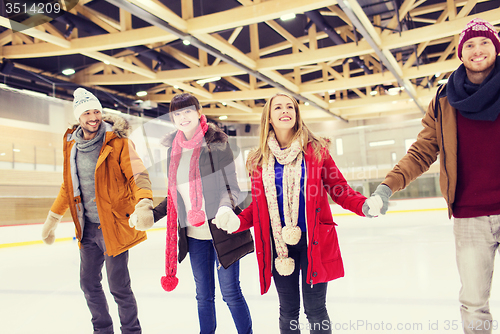 Image of happy friends on skating rink