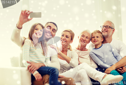 Image of happy family taking selfie with smartphone at home