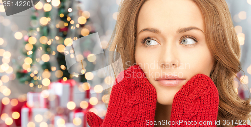 Image of happy woman in red mittens over christmas lights